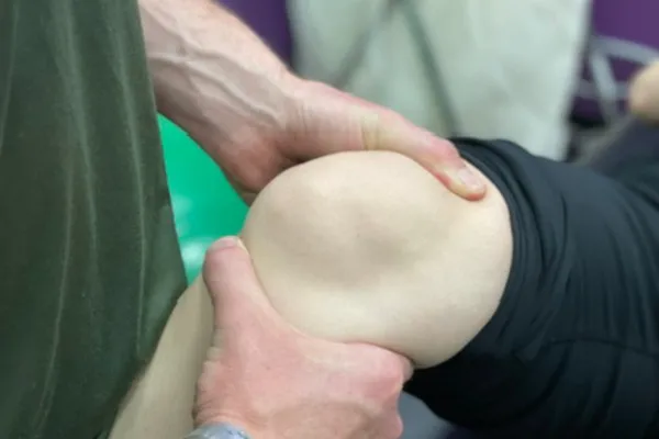 Athletic trainer evaluating an athlete's injury